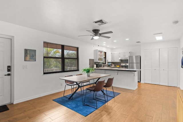 dining room featuring light wood-style floors, baseboards, visible vents, and recessed lighting