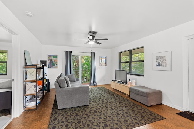 living room with dark wood-style floors, plenty of natural light, and visible vents