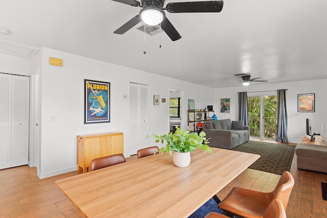 dining room with visible vents, ceiling fan, light wood-style flooring, and attic access