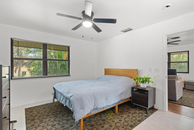 bedroom featuring visible vents, ceiling fan, baseboards, and wood finished floors