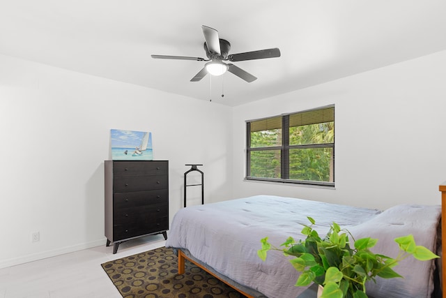 bedroom with ceiling fan and baseboards