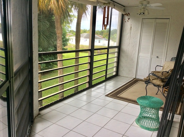 unfurnished sunroom featuring ceiling fan