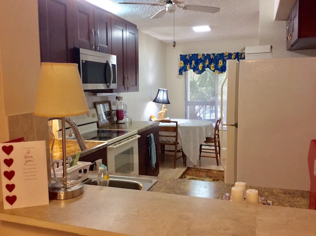 kitchen featuring white appliances, ceiling fan, and a textured ceiling