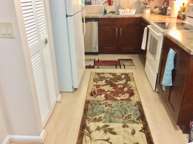 kitchen with white appliances, baseboards, light wood-style floors, light countertops, and dark brown cabinets