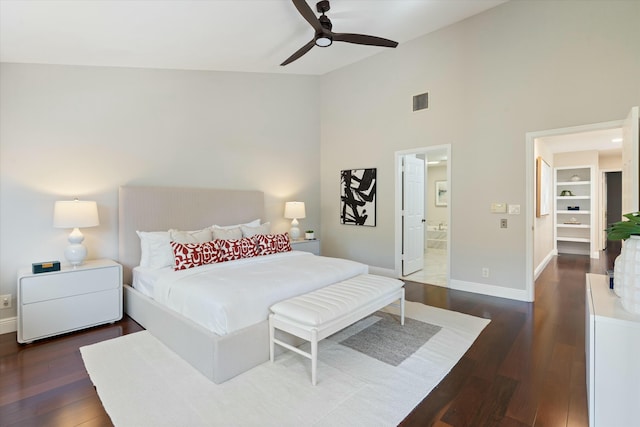 bedroom with dark wood finished floors, connected bathroom, a ceiling fan, and baseboards