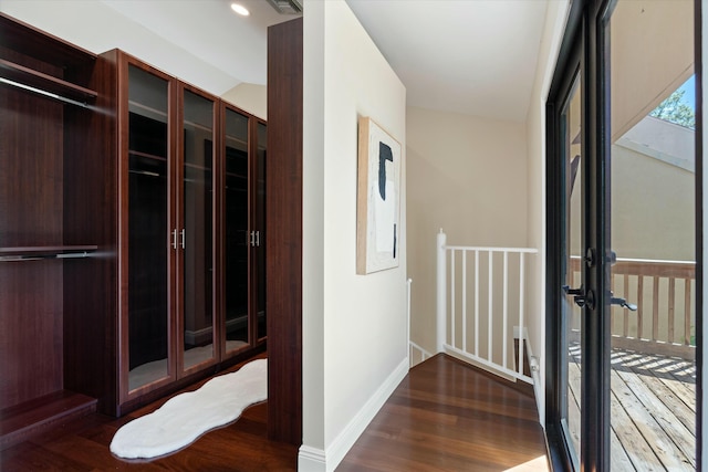 hall featuring recessed lighting, baseboards, wood finished floors, and an upstairs landing