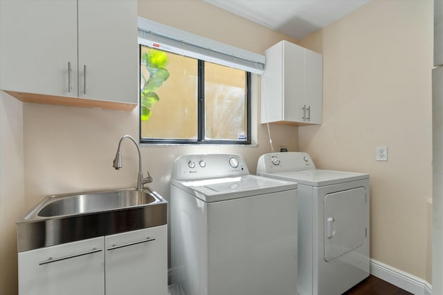 washroom with washer and dryer, baseboards, cabinet space, and a sink