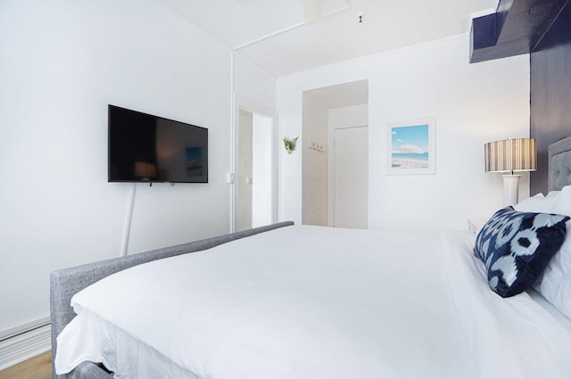 bedroom featuring a baseboard radiator and wood finished floors