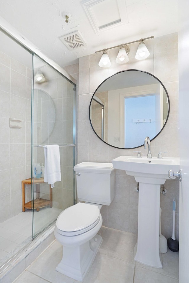 full bath featuring tile walls, visible vents, toilet, a shower stall, and tile patterned floors