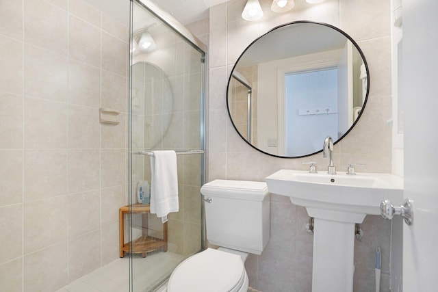 bathroom with toilet, a shower stall, tasteful backsplash, and tile walls