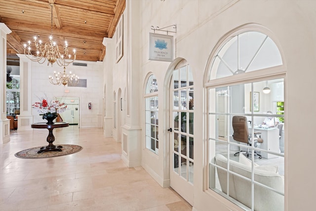 interior space featuring wooden ceiling, a chandelier, and a decorative wall