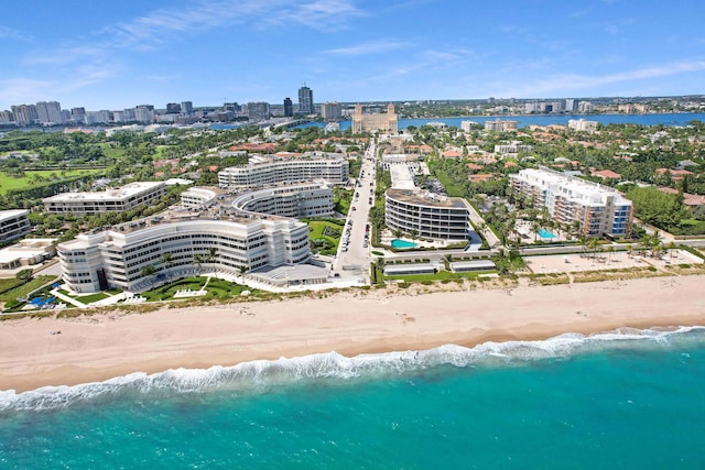 drone / aerial view featuring a beach view, a water view, and a city view