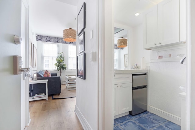 hallway featuring baseboards and wood finished floors