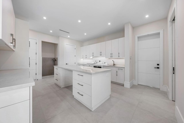 191 W Coconut Palm Rd, Boca Raton, FL 33432 - kitchen featuring a center island, white cabinets, light countertops, recessed lighting, and a sink