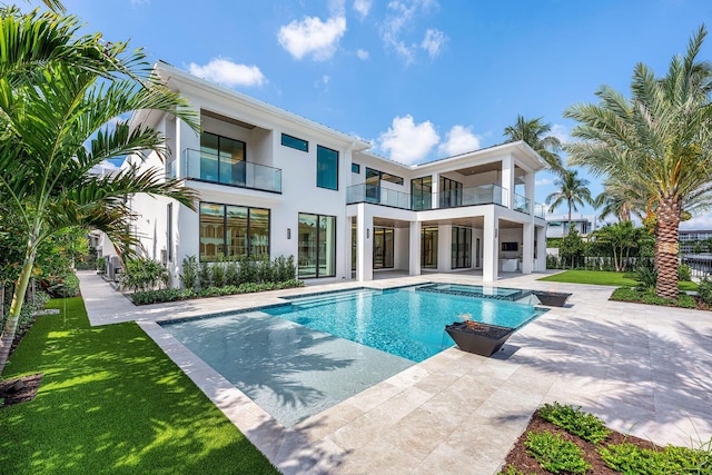191 W Coconut Palm Rd, Boca Raton, FL 33432 - rear view of property with stucco siding, an outdoor pool, a patio, a balcony, and a yard