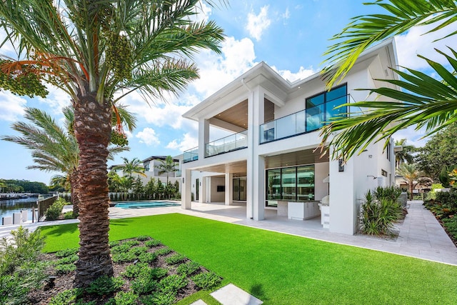 191 W Coconut Palm Rd, Boca Raton, FL 33432 - back of house featuring a balcony, stucco siding, a patio, and a yard