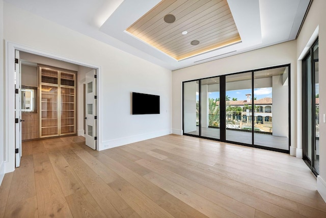 191 W Coconut Palm Rd, Boca Raton, FL 33432 - empty room with a tray ceiling, light wood-style floors, and baseboards