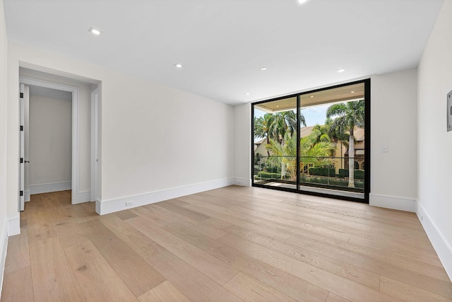 191 W Coconut Palm Rd, Boca Raton, FL 33432 - empty room featuring light wood-type flooring, floor to ceiling windows, baseboards, and recessed lighting