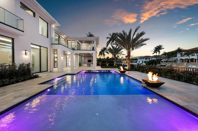 191 W Coconut Palm Rd, Boca Raton, FL 33432 - pool at dusk featuring a fire pit and a patio area