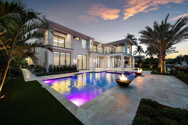 191 W Coconut Palm Rd, Boca Raton, FL 33432 - back of property featuring a balcony, an outdoor fire pit, stucco siding, and a patio area
