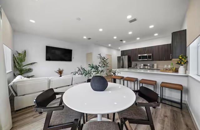 dining space with recessed lighting, baseboards, visible vents, and light wood finished floors