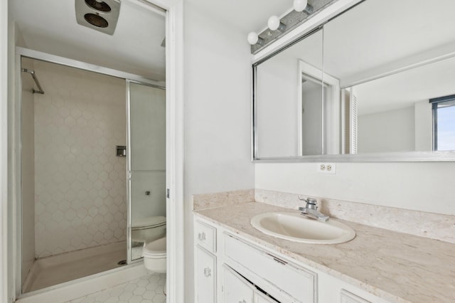 bathroom featuring tile patterned flooring, a shower stall, toilet, and vanity