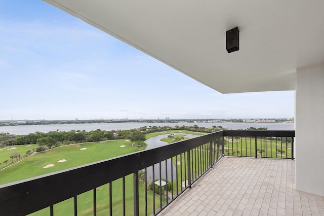 balcony featuring golf course view and a water view