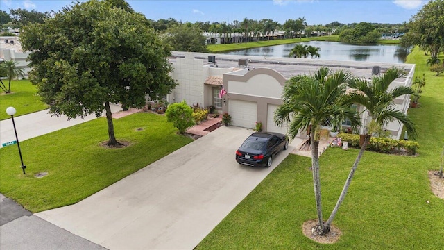 view of front facade featuring concrete driveway, a water view, an attached garage, and a front lawn