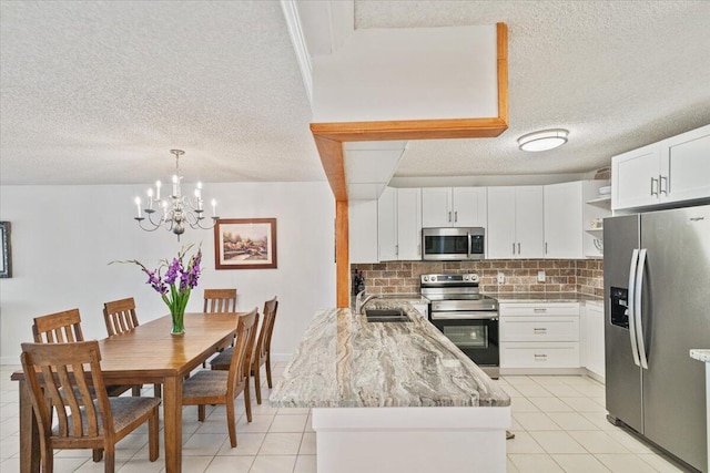 kitchen with white cabinets, appliances with stainless steel finishes, decorative light fixtures, open shelves, and a sink