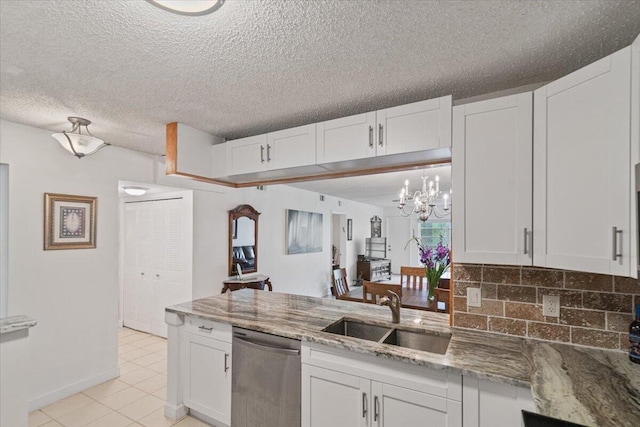 kitchen featuring dishwasher, tasteful backsplash, a sink, and white cabinets