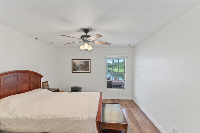 bedroom featuring ceiling fan, baseboards, and wood finished floors