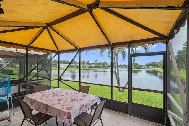 sunroom featuring a water view and vaulted ceiling