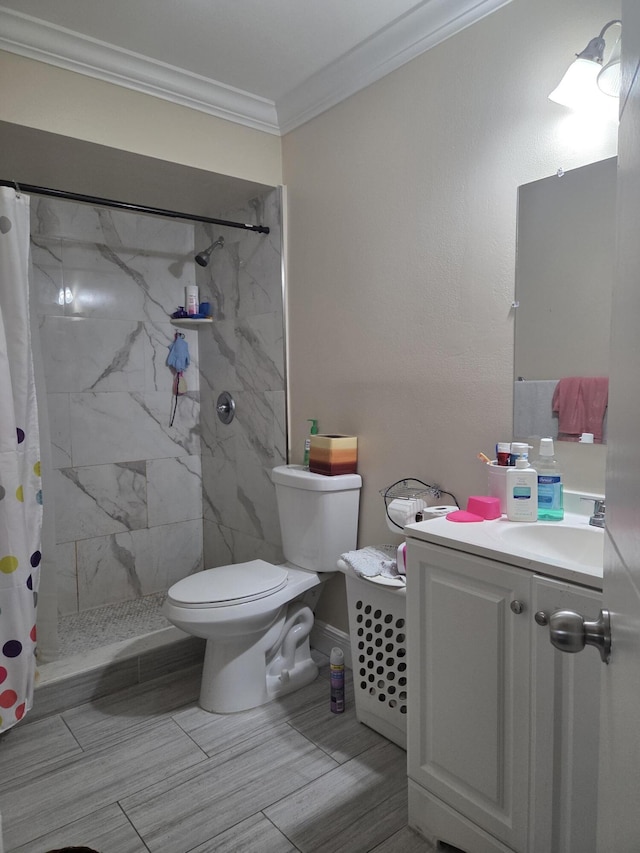 full bath with toilet, ornamental molding, a tile shower, and vanity