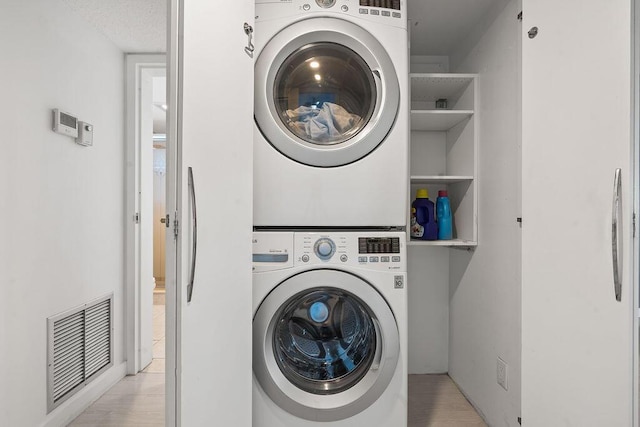 washroom featuring laundry area, visible vents, and stacked washer / dryer