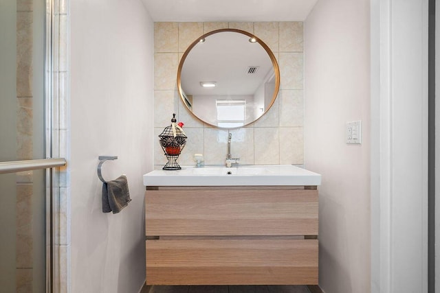 full bath featuring an enclosed shower, visible vents, tile walls, and vanity