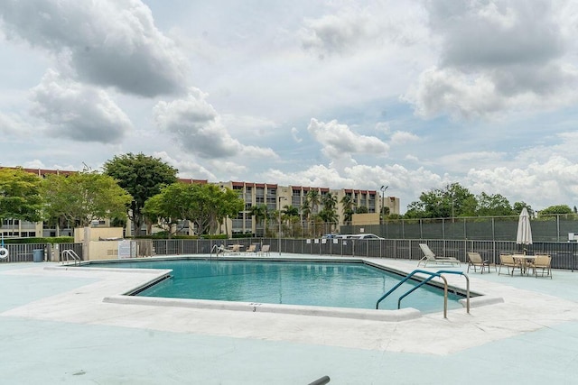 pool featuring fence and a patio