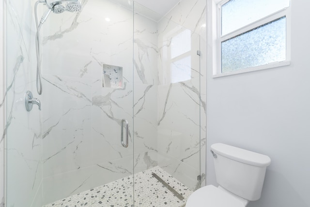 bathroom with a marble finish shower and toilet