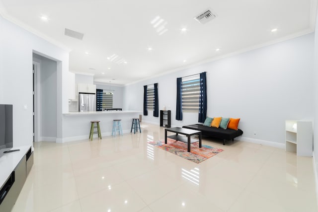 living room featuring ornamental molding, visible vents, and light tile patterned floors