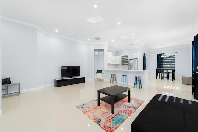 living area with ornamental molding, light tile patterned flooring, and baseboards