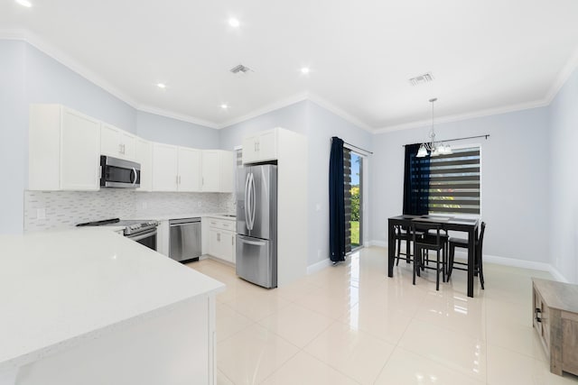 kitchen with crown molding, stainless steel appliances, visible vents, and decorative backsplash