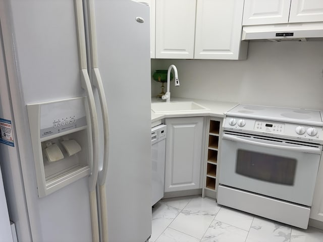 kitchen with white appliances, white cabinets, marble finish floor, under cabinet range hood, and a sink