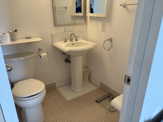 bathroom with tile patterned flooring, toilet, and baseboards