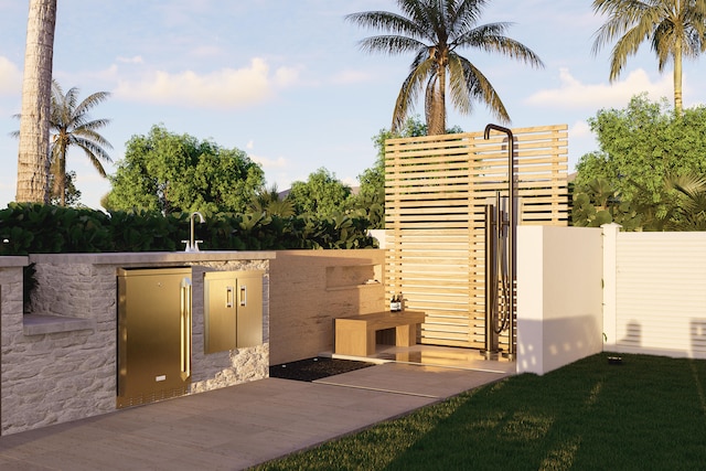 view of patio with an outdoor kitchen and fence