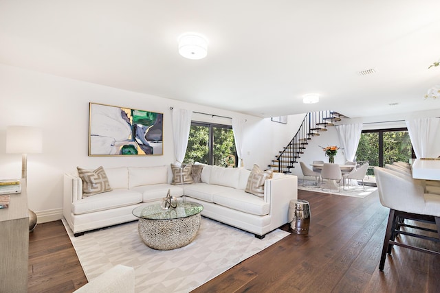 living room featuring stairway, a wealth of natural light, wood finished floors, and visible vents