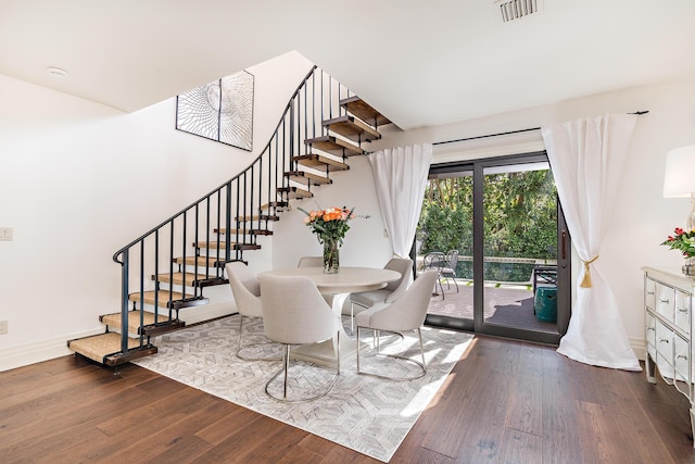 dining area featuring baseboards, stairs, wood finished floors, and visible vents