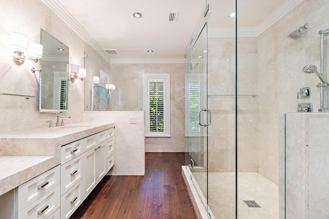bathroom with crown molding, tile walls, a stall shower, vanity, and wood-type flooring