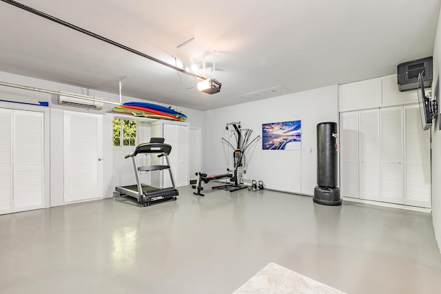 workout area featuring a garage and a wall unit AC