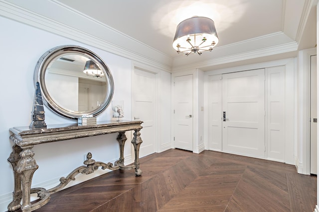 entrance foyer featuring an inviting chandelier and crown molding