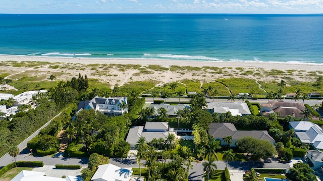 drone / aerial view featuring a beach view, a residential view, and a water view
