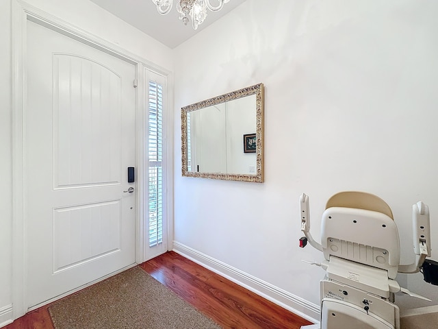 entryway featuring a notable chandelier, baseboards, and wood finished floors